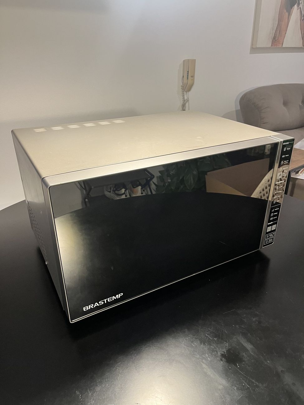 O mesmo micro-ondas em ângulo, mostrando a lateral em inox e a profundidade.