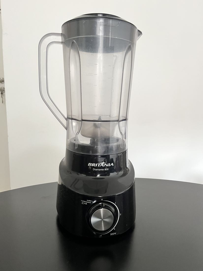 Liquidificador Britânia preto visto de frente, com o copo transparente encaixado na base.